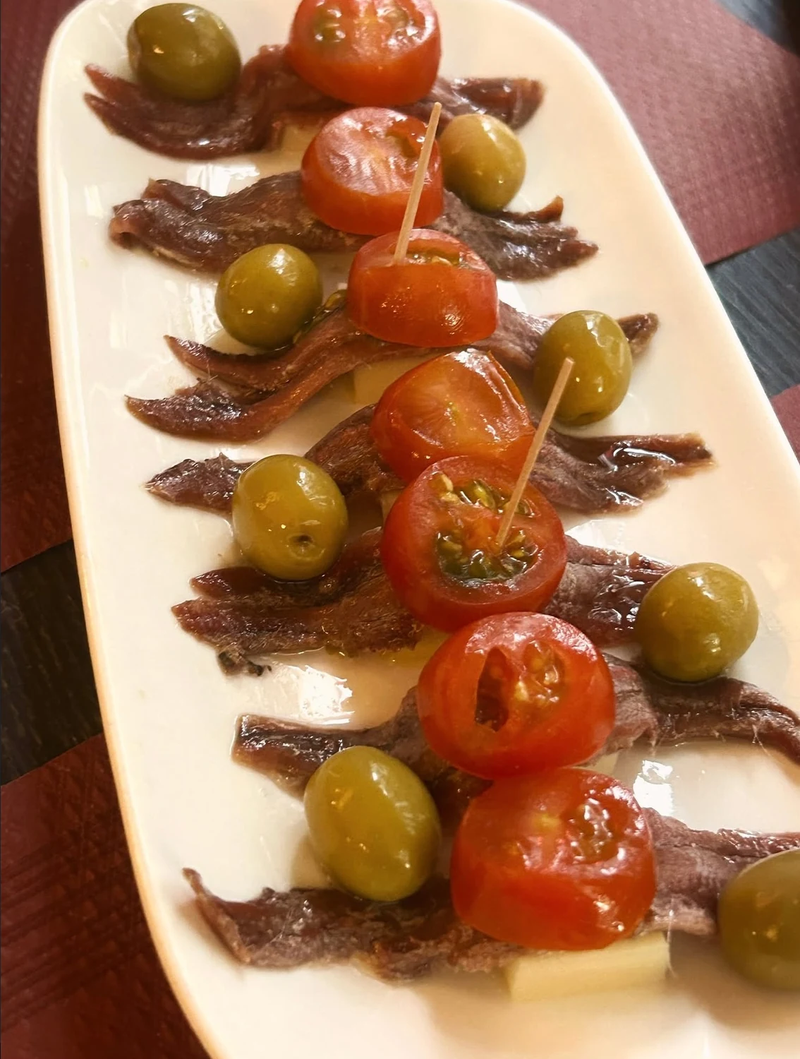 Anchoas con queso manchego, tomate cherry y aceitunas.