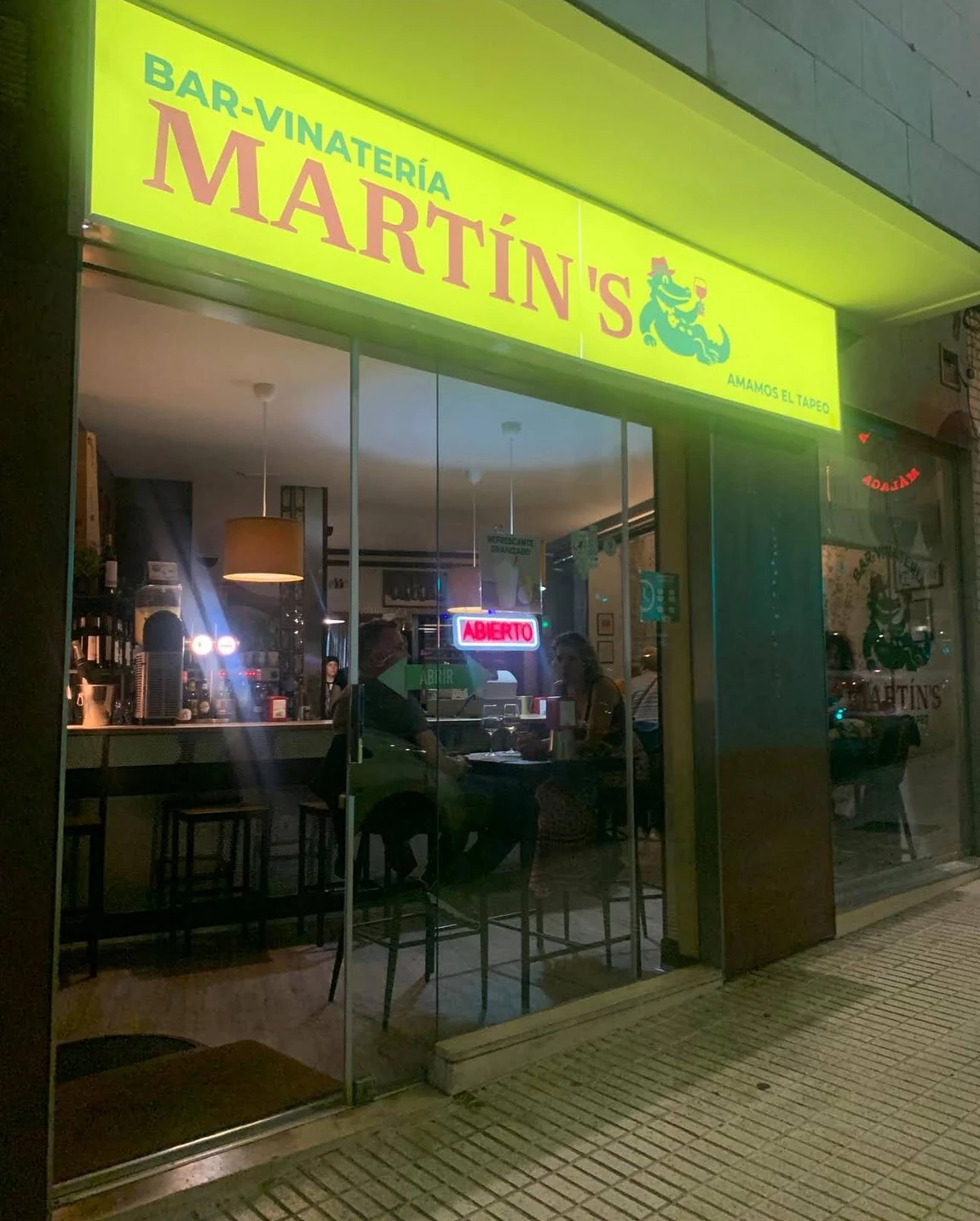 La entrada de Bar-Vinatería Martín’s y su característico letrero amarillo.