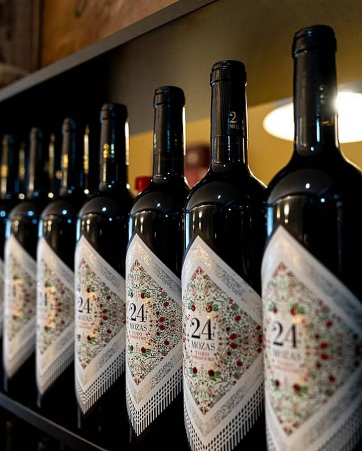 Una fila de botellas de vino 24 Mozas.